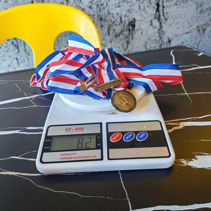 Medals being weighed on a digital scale, the same measurement discipline this encoding test uses